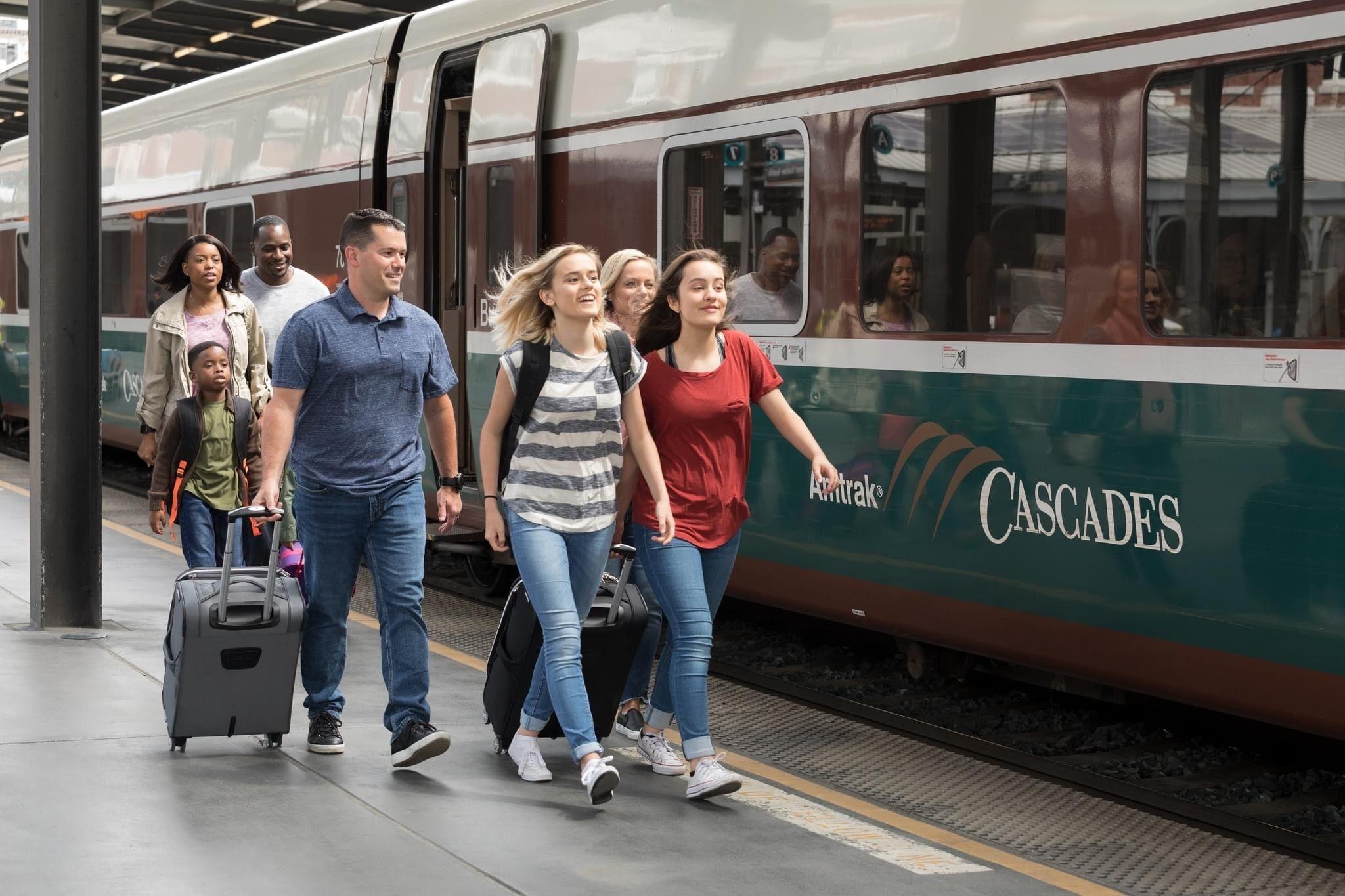 A family next to an Amtrak train