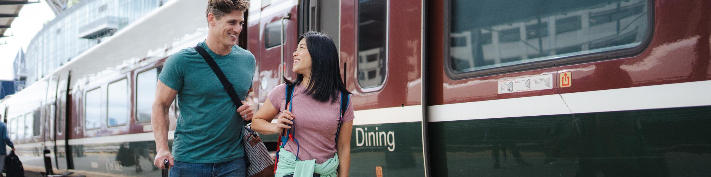 Two people walking alongside an Amtrak Cascades Talgo train