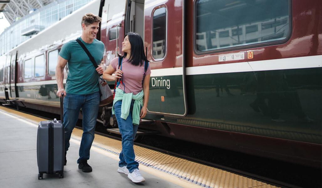 Two people walking alongside an Amtrak Cascades Talgo train