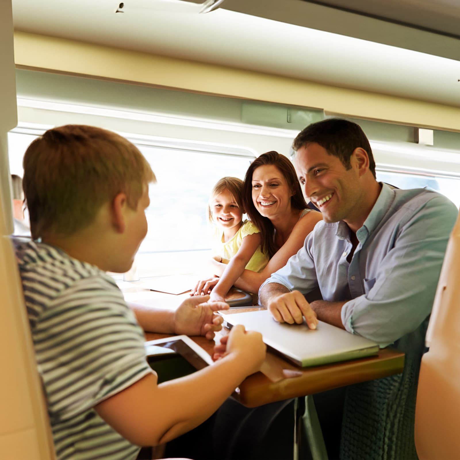 Family sitting across a table from one another on the train